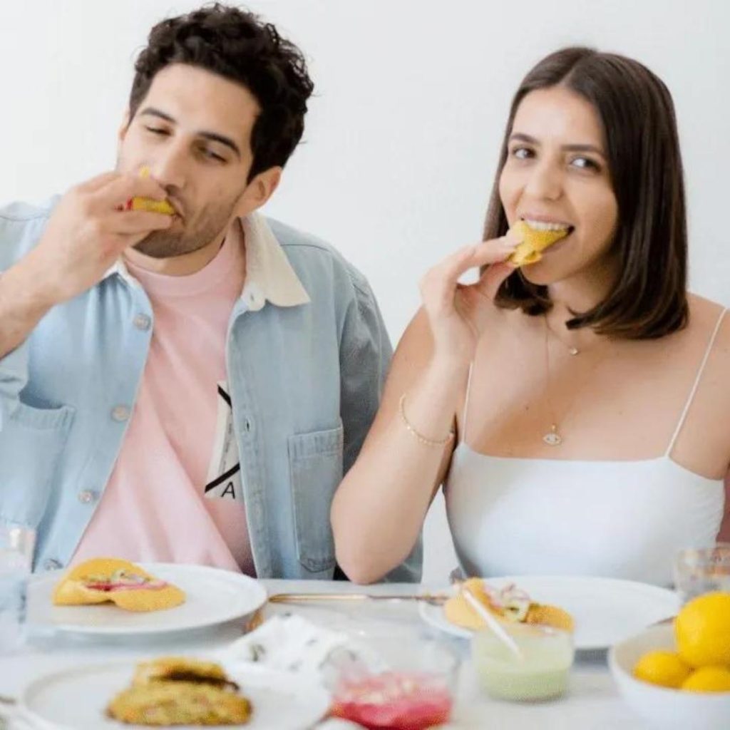Tallene and Sirak sitting at a table full of breakfast options