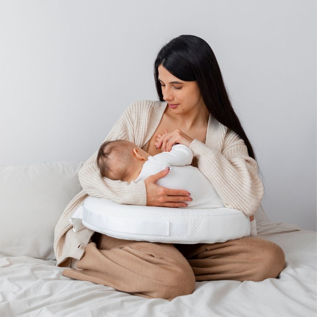 Mother breastfeeding baby while learning about PCOS after pregnancy.
