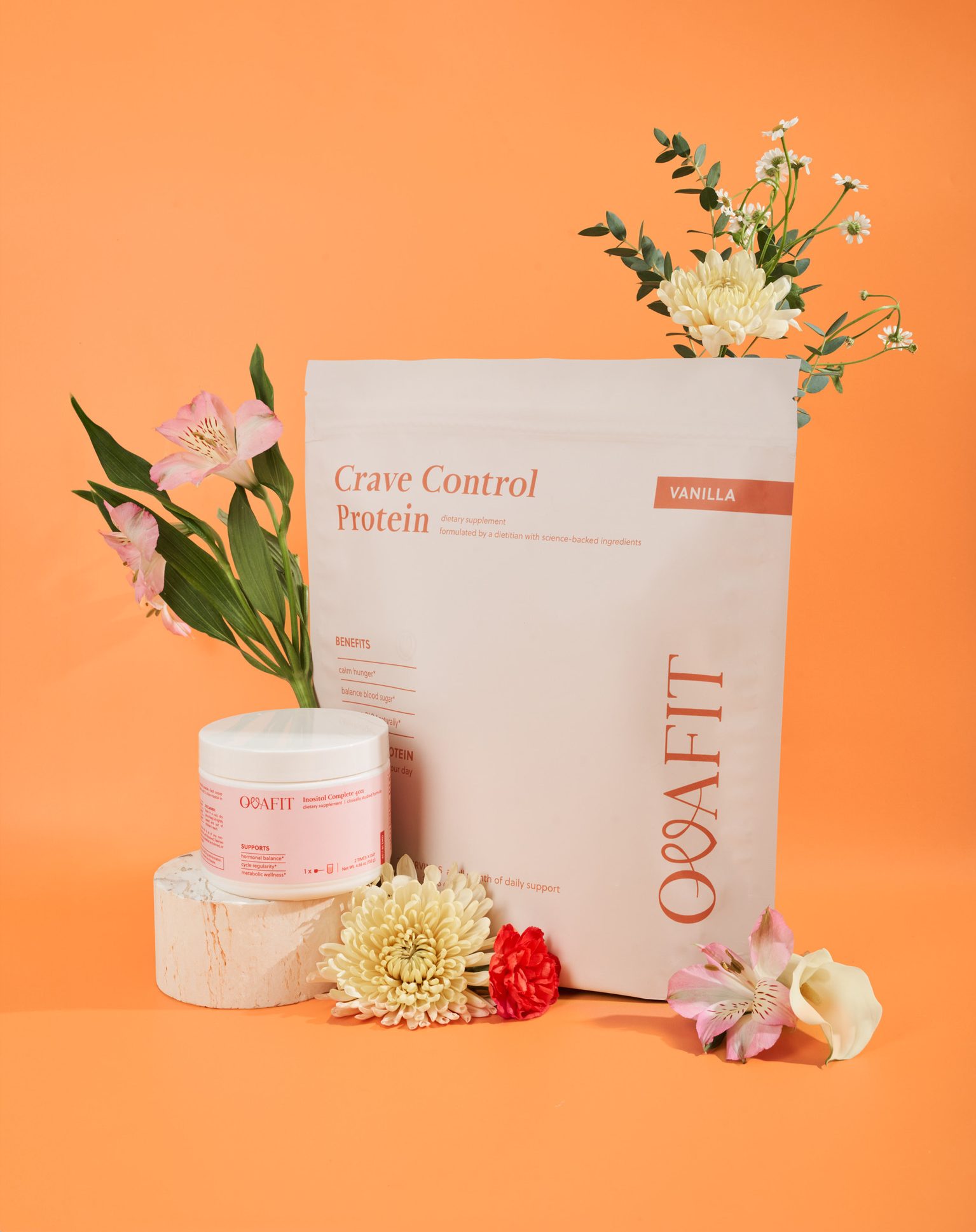 Orange background with a Crave Control vanilla protein bag, a white jar, and a bouquet of pink and yellow flowers.